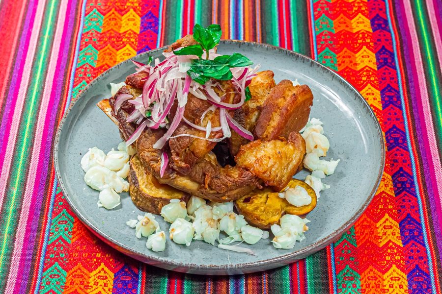 Chicharrón de cerdo con camote, mote y salsa criolla